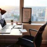 Um escritório moderno e organizado com dois laptops, uma agenda aberta e uma luminária, simbolizando o planejamento inicial de um empreendimento digital.